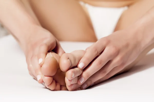 Mulher sentada e massageando seus pés cansados — Fotografia de Stock