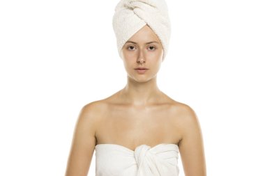 Bedeninde havlu, beyaz arka planda kafası olan genç bir kadının stüdyo fotoğrafı.