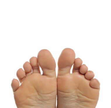 Bir kadının çıplak ayaklarının görülebilir tabanları ve ayak parmakları, pürüzsüz cildi ve temiz dokusu, beyaz bir arka planda stüdyo çekimi.