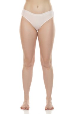 Beyaz arka planda duran iç çamaşırlı kadın bacakları ve ayaklarının stüdyo fotoğrafları..