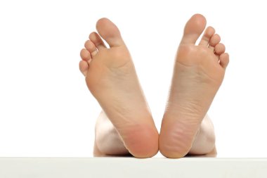 Bir kadının arka görüntüsü çıplak ayakla yükselir ve tabanları pürüzsüz görünür, beyaz arka planda stüdyo çekimi.