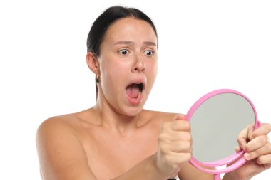 Stüdyo resmi, siyah saçlı, makyajsız, aynasız ve beyaz arka planda şoka uğramış bir kadın.