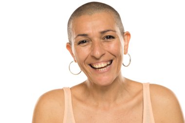 Studio shot of bald woman in tank top smiling confidently with natural look on white background