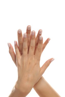 Beyaz arka planda birbirine dokunan bir kadının düzgün manikürlü ellerinin stüdyo fotoğrafı.