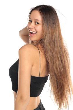 Stüdyo resmi, uzun siyah saçlı, gülümseyen, siyah bluzlu, beyaz arka planda omzunun üzerinden bakan doğal bir kadın..