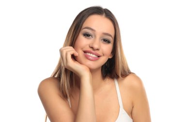 Uzun kahverengi saçlı ve makyajlı, beyaz bluzlu, beyaz bir arka planda çenesini dinlendirirken çekilmiş samimi bir gülümseme..