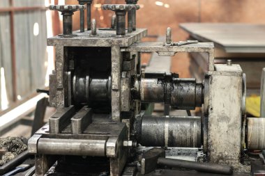 Fabrika atölyesinde çelik silindirleri ve mekanik parçaları olan endüstriyel metal bükme makinesi..