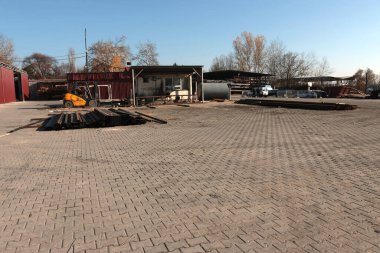 Arka planda çelik malzemeler ve forkliftle boş endüstriyel metal depolama alanının geniş açı görüntüsü.