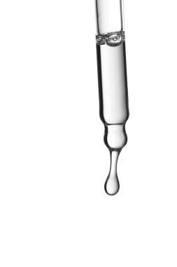 Temiz bir kozmetik sıvısıyla beyaz arka planda izole edilmiş bir şekilde bir damla oluşturan cam pipetin stüdyo görüntüsü..