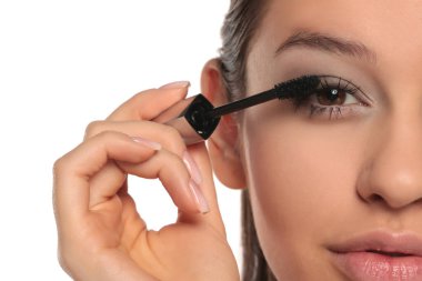 Maskara süren genç bir kadının yarım portresi, beyaz bir arka planda stüdyo çekimi..