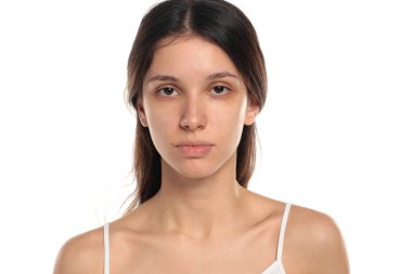 Esmer ve makyajsız bir kadının beyaz bir arka planda kamera, portre, vesikalık fotoğrafına baktığı bir stüdyo resmi..