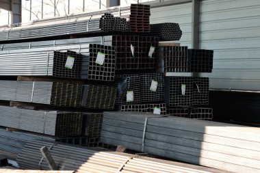 Endüstriyel metal bir depoda etiketli, kare ve dikdörtgen çelik bölme profillerinin geniş görünümü.