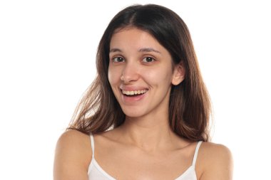 Mutlu bir yüzü olan esmer bir kadının stüdyo fotoğrafı. Beyaz arka planda makyaj olmayan doğal bir resim..