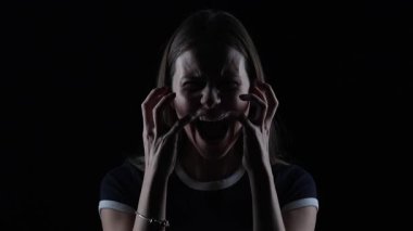 4K sinematik, karanlık, çaresiz genç bir kadının dramatik ışıkta duygusal acı içinde çığlık attığı portresi.