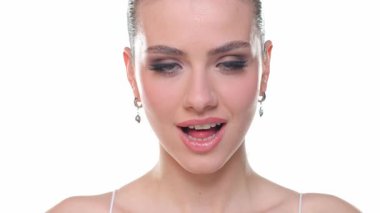 Kameraya seni seviyorum diyen genç bir kadın, gülümseyen ve arkasını dönen, güzellik portresi, beyaz arka planda stüdyo çekimi