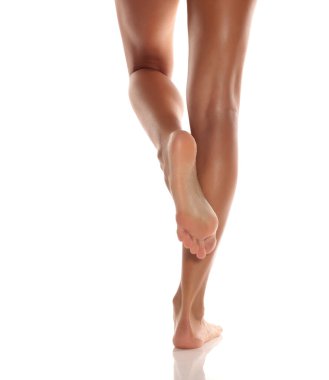Bir kadının bronzlaşmış, bakımlı bacakları ve ayakları, dikiz aynası, beyaz bir arka planda poz..