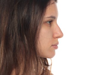 Beyaz arka planda makyajsız esmer bir kadının yan görünümü..