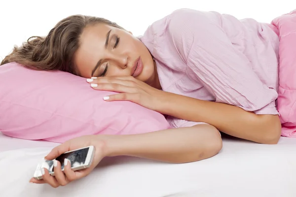 Женщина спит с телефоном в руке — стоковое фото