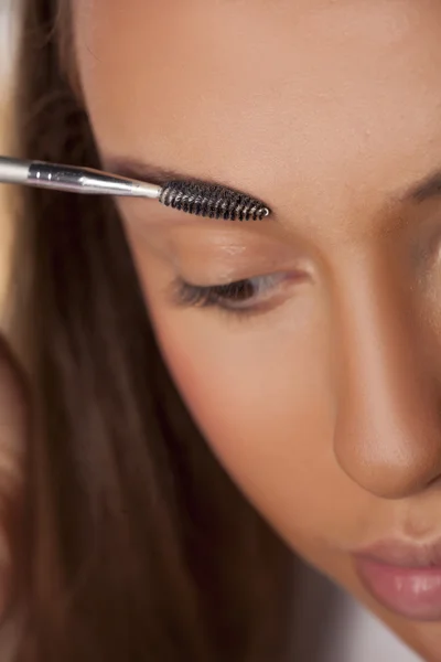 Girl combing her eyebrows — Stock Photo, Image