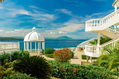 Karayip okyanus arka planında güzel beyaz çardak ve tropikal bahçe, yaz dağı manzarası, Sosua, Puerto Plata, Dominik Cumhuriyeti