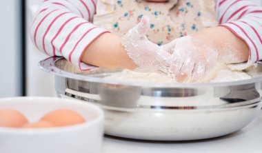 Un ile Mutfak 'ta Pasta Fırını yapan Küçük El' in ayrıntıları. Bebek Aşçı Konsepti.