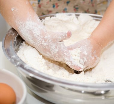 Un ile Mutfak 'ta Pasta Fırını yapan Küçük El' in ayrıntıları. Bebek Aşçı Konsepti.