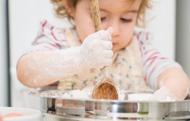 Ufaklık mutfakta un ile pasta fırını yapıyor. Bebek Aşçı Konsepti.