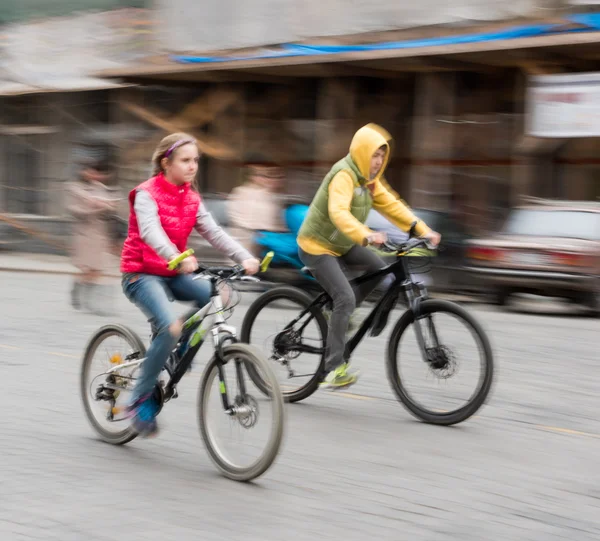 Bambini che vanno in bicicletta su una strada della città — Foto Stock