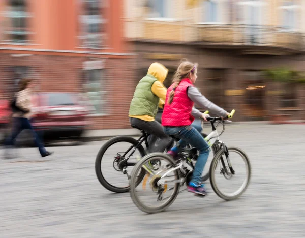 Children riding bicycles on a city street — Stock Photo, Image