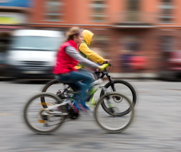 Crianças andando de bicicleta em uma rua da cidade — Fotografia de Stock