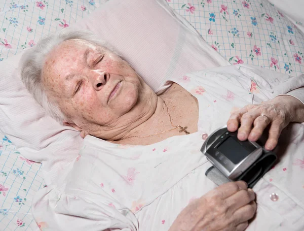 Oude vrouw met arteriële druk maatregel — Stockfoto