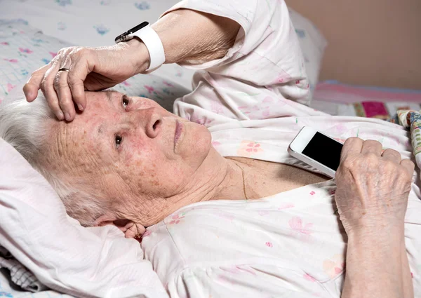 Stara kobieta z pokładzie smartwatch i smartphone — Zdjęcie stockowe