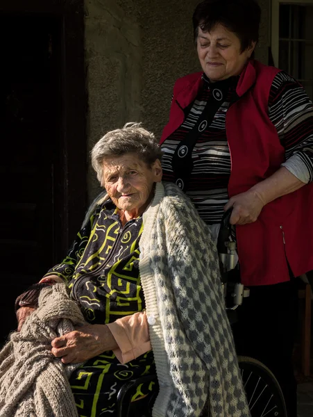 Vieja en silla de ruedas y su hija — Foto de Stock