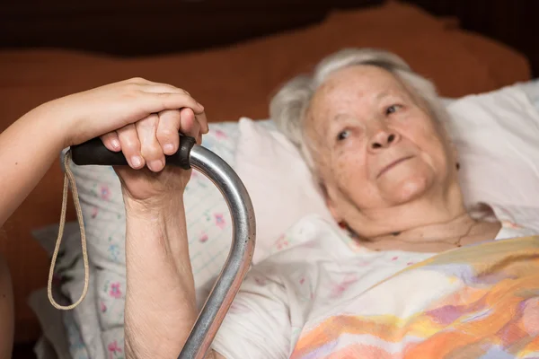 Manos cariñosas sosteniendo las manos de anciana — Foto de Stock