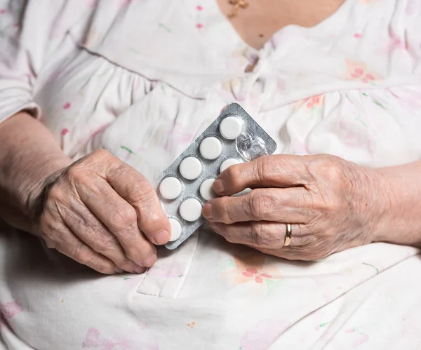 Vieille femme tenant le médicament dans les mains — Photo