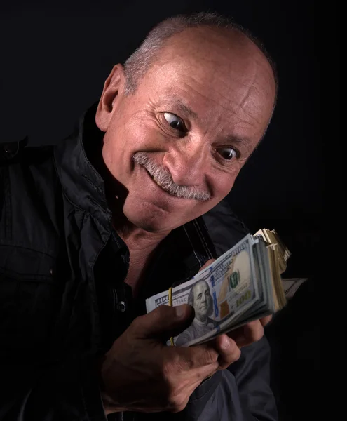 Sly senior man met dollarbiljetten — Stockfoto