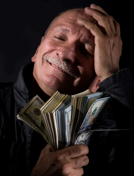 Sly homem sênior segurando notas de dólar — Fotografia de Stock