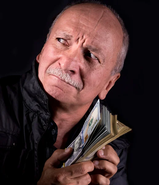 Sly senior man holding dollar bills — Stock Photo, Image