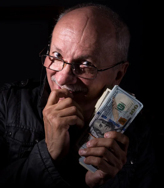 Sly senior man holding dollar bills — Stock Photo, Image