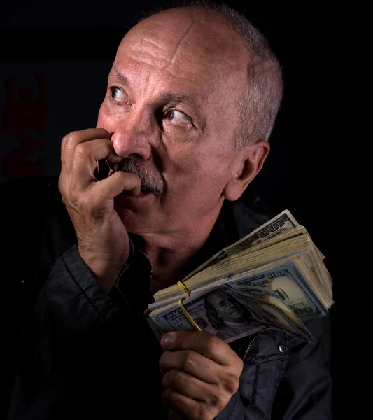 Sly senior homme tenant des billets en dollars — Photo