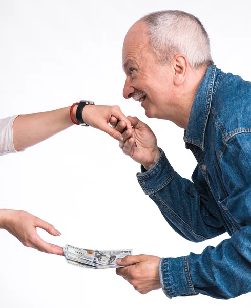 Man kissing a woman's hand and giving dollar bills — Stock Photo, Image