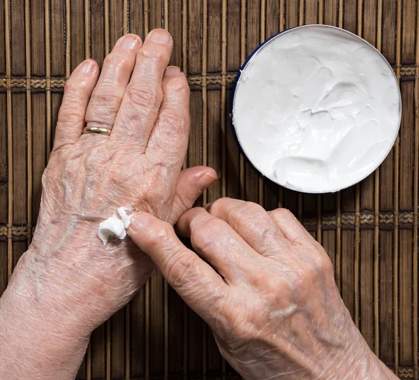 Las mujeres de edad manos aplicar crema —  Fotos de Stock