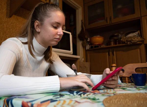 Adolescente Menina Tomando Café Manhã Cozinha Enquanto Usa Seu Telefone — Fotografia de Stock