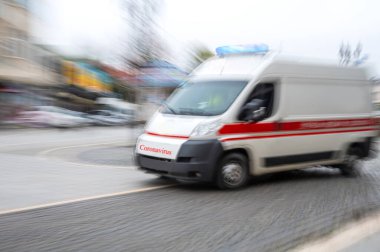 Bir ambulans hareket bulanıklığı içinde caddede hızla giden acil çağrıya cevap veriyor. Odaklanmamış resim. Sağlık hizmetleri kavramı