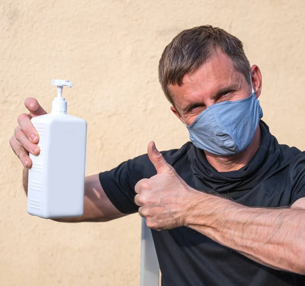 医療と医療の概念 男は屋外で手の消毒剤のボトルを保持 — ストック写真