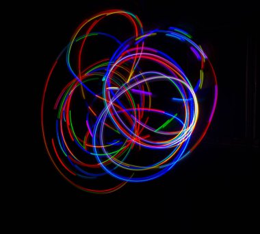 Siyah zemin üzerine ışık tarafından çizilmiş çok renkli çizgileri özetle. Lazer hatları