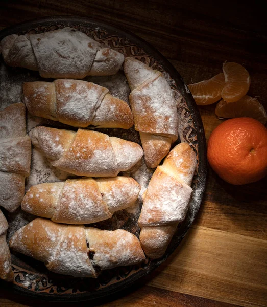厨房桌上放满了果酱和橘子的甜面包卷 — 图库照片