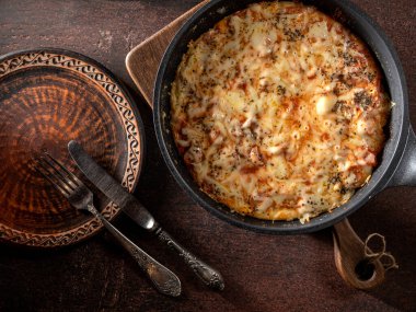 Domatesli ev yapımı pizza, ahşap bir masada mozzarella ve jambon.