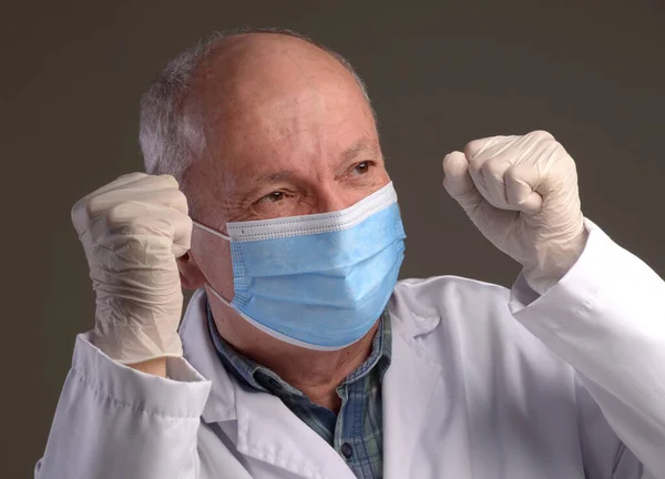 Healthcare and medical concept. Happy senior medical doctor in protective gloves and face mask over grey background