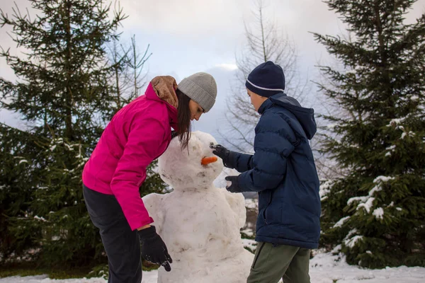 Mãe Com Filho Fazendo Boneco Neve Floresta Inverno — Fotografia de Stock